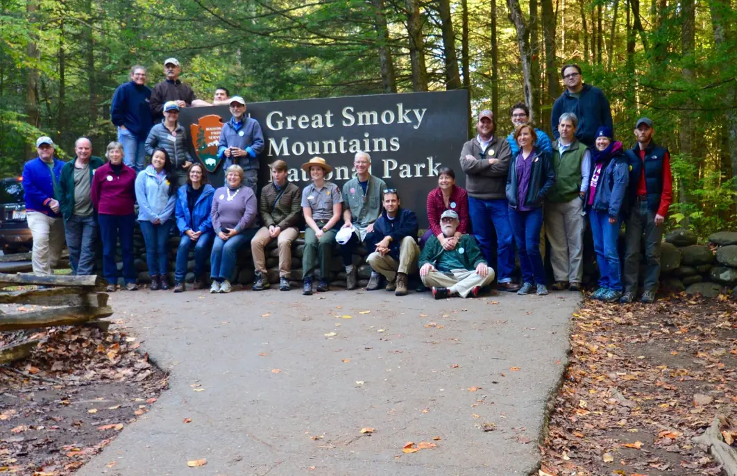 Park Rangers in front of a sign